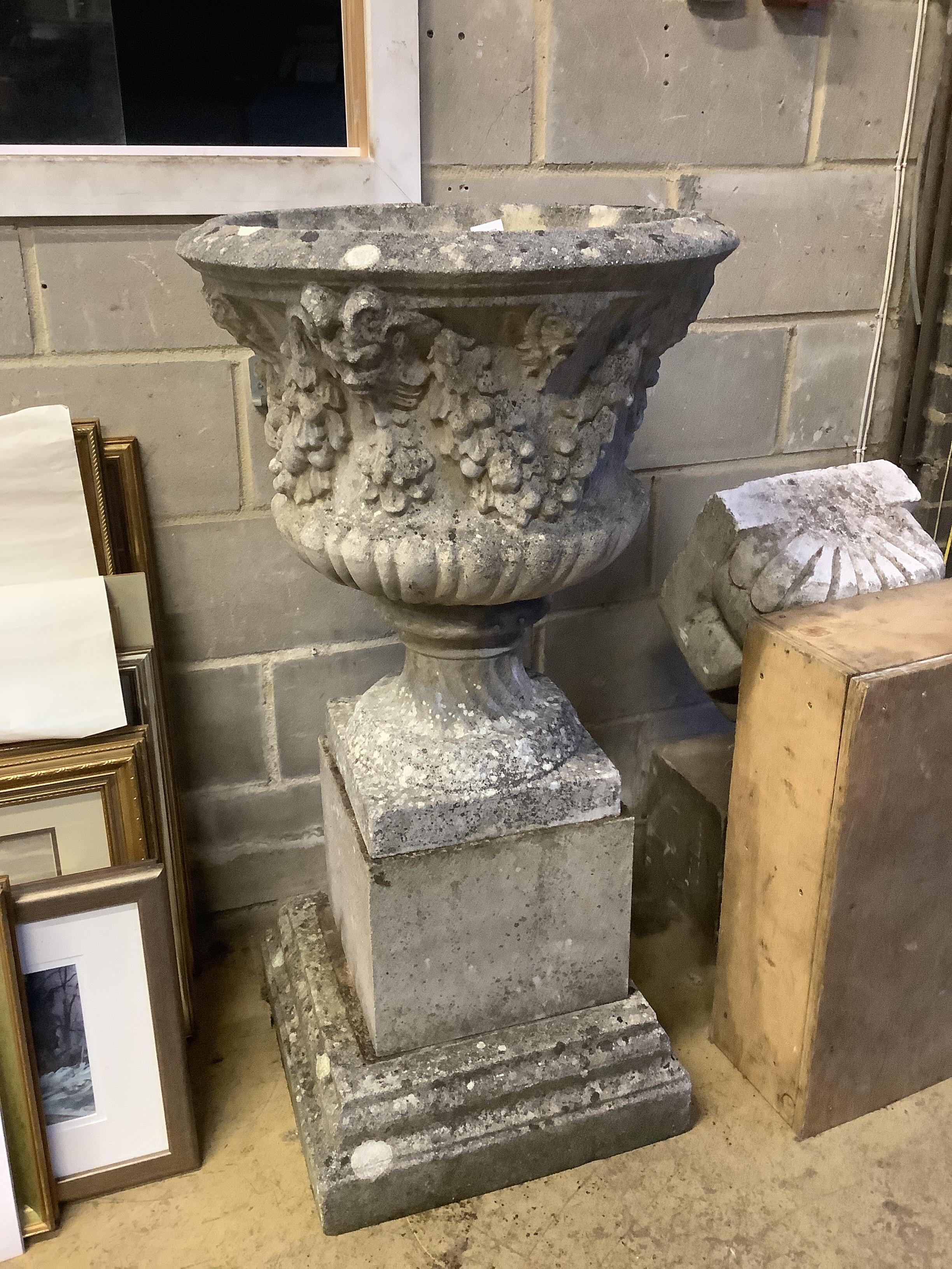 A reconstituted stone campana garden urn on square plinth, diameter 58cm, height 112cm